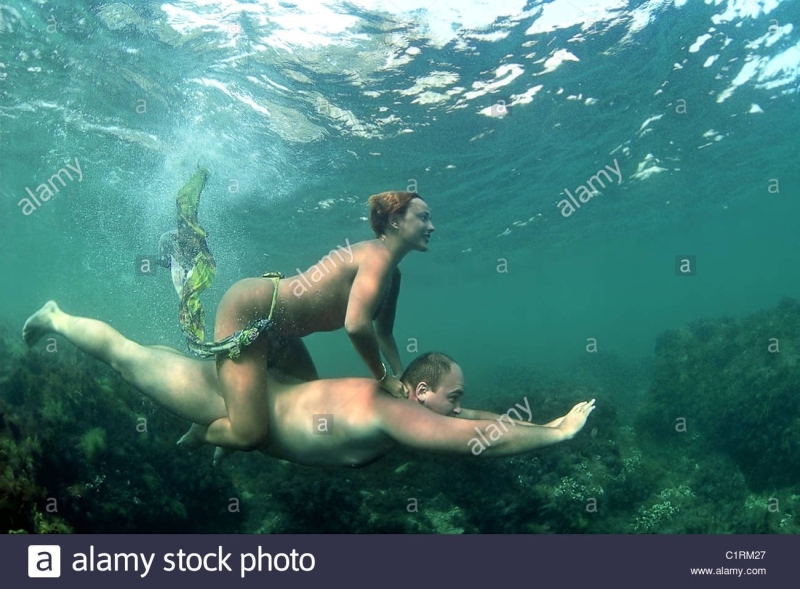 Голые женщины и парень в воде